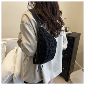 Detail of black leopard print crossbody bag with matte texture and adjustable strap