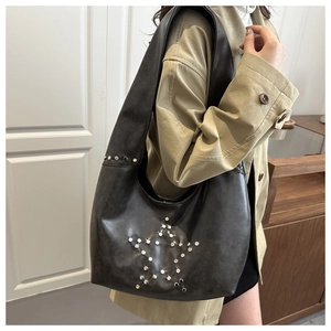Close-up of vintage grey crescent bag with metallic star rivets on soft leather texture