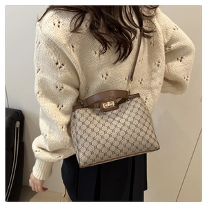 Detailed side view of a vintage monogram tote bag styled with a white cable knit sweater