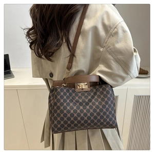 Detail of vintage monogram canvas handbag with leather trim and metallic turn-lock closure
