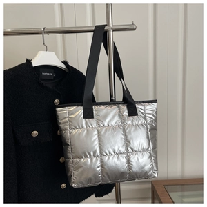 Détail du sac fourre-tout argenté métallisé avec bandoulière noire et motif à carreaux