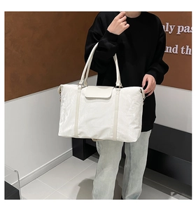 Dettaglio borsa da viaggio bianca in nylon impermeabile con patta magnetica e manici in nastro