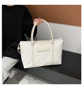 Dettaglio della grande borsa da viaggio bianco crema in nylon micro-testurizzato con patta
