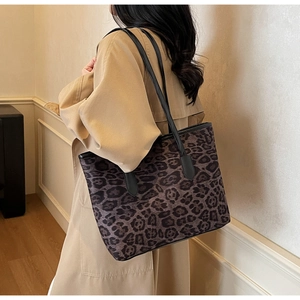 Close-up of leopard print tote bag with black leather handles and spacious interior