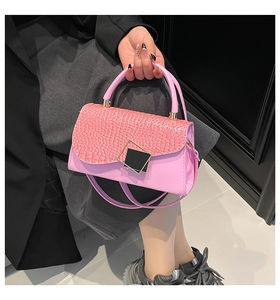 Detail of pink faux leather handbag featuring crocodile texture flap and geometric buckle
