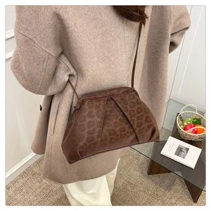 Fashionable leopard print shell bag shown as crossbody style in a warm lifestyle setting