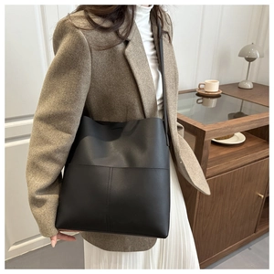Detail of minimalist black leather tote bag with geometric stitching for daily use
