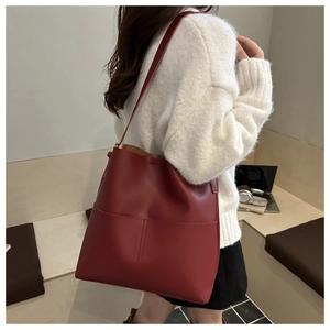 Detail view of burgundy leather tote bag showing drape and stylish vertical stitching