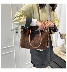Close-up of brown plush tote bag texture with leather handles and drawstring detail