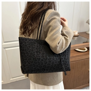 Detail of a large leopard print tote bag with black straps in a modern lifestyle setting