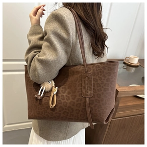 Sac fourre-tout à motif léopard marron porté à l'épaule avec breloque peluche