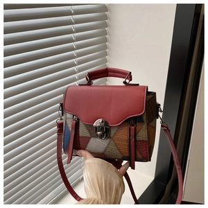 Detail of vintage square crossbody bag featuring colorful geometric patchwork and red flap