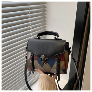 Detailed close-up of colorful leather patchwork pattern and metal lock on the handbag