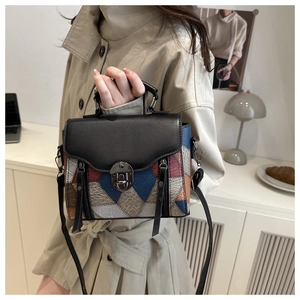 Dettaglio di borsa vintage in pelle patchwork con chiusura girevole e cerniere decorative