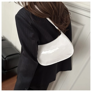 Back view of a white patent leather baguette bag styled with a pinstripe blazer