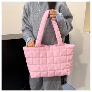 Close-up of pink quilted puffer tote bag featuring square stitching and wide handles