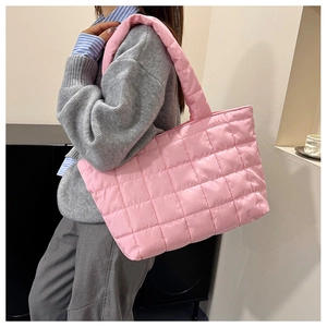 Pink quilted tote bag with large square stitching and padded shoulder strap detail