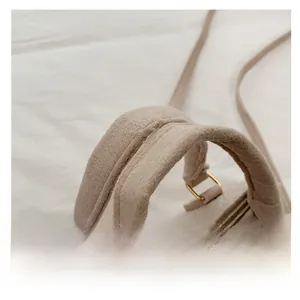 Detail of oatmeal fuzzy wool handbag featuring a sturdy handle and gold metal zipper