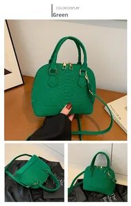 Detailed close-up of emerald green snakeskin embossed texture on shell handbag