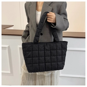 Detailed view of the quilted black nylon tote bag showing the soft padded texture and stitching