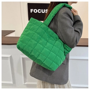 Detail of bright green quilted tote bag showing nylon texture and spacious padded design