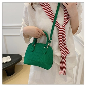 Detail view of the bright green embossed crocodile leather texture and golden hardware