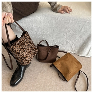 Close-up of three faux suede bucket bags featuring leopard print and solid brown textures