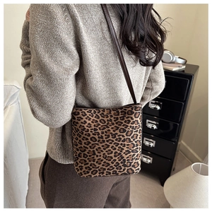 Close-up of leopard print shoulder bag with brown leather strap in a lifestyle setting