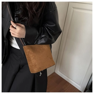 Brown matte suede bucket bag shown in a lifestyle crossbody wear style shot