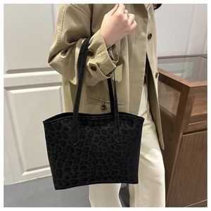 Detail of black leopard print suede tote bag showing texture and slim leather shoulder straps