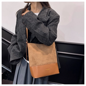 Nahaufnahme der braunen Wildleder-Patchworktasche mit goldenem Lederschriftzug