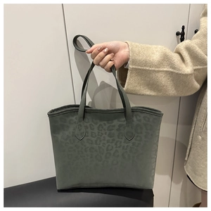 Close-up of leopard print tote bag with matte suede texture and slim double handles