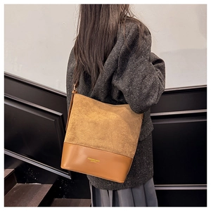 Detailansicht der Wildleder-Eimertasche mit zwei Texturen und goldener Beschriftung
