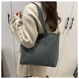 Detail of grey leopard embossed suede tote bag worn over a beige coat for a stylish commute