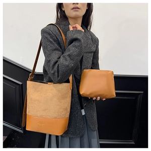Detail of suede patchwork bucket bag and matching pouch with gold stamped lettering