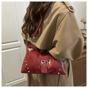 Mannequin portant un sac à bandoulière rouge vintage avec clous argentés et boucle en métal