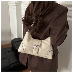 Detail of off-white rivet tote bag on shoulder, featuring silver metal hardware accents