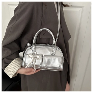 Silver metallic bowling bag with pearl bow charms and dual flap pockets detail