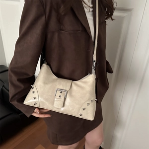 Retro cream faux leather hobo bag with silver studs and belt buckle detail on model