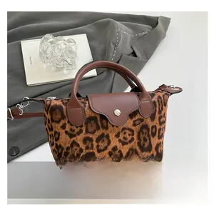 Close-up of leopard print shoulder bag with brown leather trim and silver metal buckle