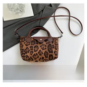 Detail shot of leopard print handbag with leather flap and strap on a stylish background
