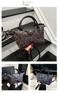 Detailansicht der schwarzen Nylon-Damentasche mit Leopardenmuster, Ledergriffen und Silberdekor