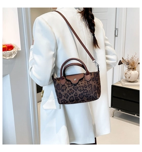 Detail der Nylon-Handtasche mit Leopardenmuster, braunen Ledergriffen und Metallschnalle