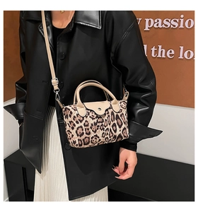 Detail of leopard print nylon bag with beige leather trim and crossbody strap on model