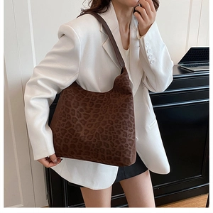 Close-up of vintage leopard print hobo bag worn with a white blazer for a chic look