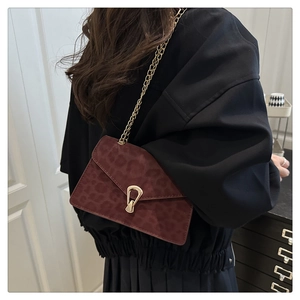 Détail du sac bandoulière léopard bordeaux avec chaîne dorée et fermoir métallique