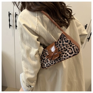 Detail of leopard print shoulder bag with brown patent leather trim and bow knot