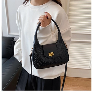 Detail of black woven shoulder bag featuring premium texture and gold metal buckle