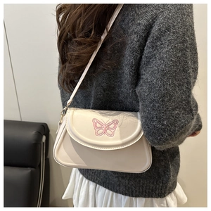 Detailansicht der rosa Schmetterlingsstickerei auf der cremeweißen Leder-Schultertasche
