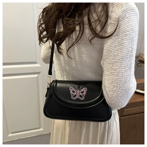 Detailansicht der rosa Schmetterlingsstickerei auf einer schwarzen PU-Handtasche